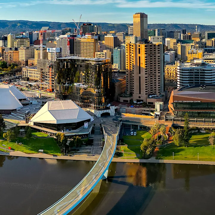 The finished puzzle: Adelaide's city centre and the white Festival Centre roofs above the river, with a curved footbridge crossing the water